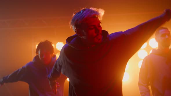 Three Hiphop Guys Dancing Synchronously in Nightclub