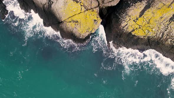 aerial view of waves crashing rocks