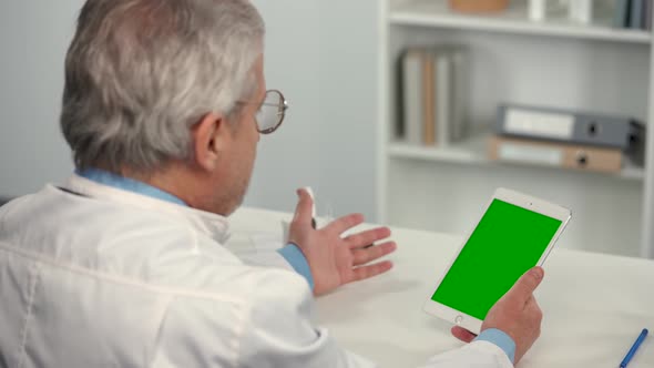 Male Doctor Consults Patient Using Tablet with Green Screen Chroma Key