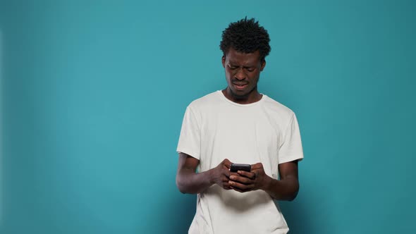 Confused Man Using Smartphone for Text Messages