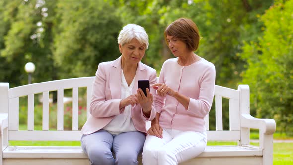 Happy Senior Women with Smartphone at Summer Park