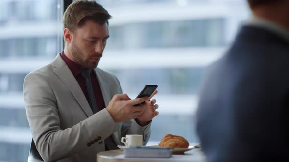 Serious Entrepreneur Sitting Cafe Using Mobile Phone Surfing Internet in Office