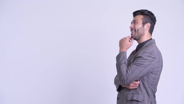 Profile View of Happy Bearded Persian Businessman Thinking