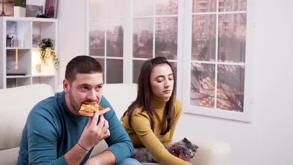 Focused Couple Sitting on Couch Watching Tv