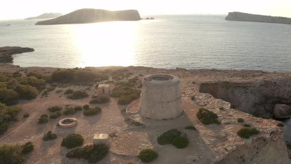 Aerial view of lookout tower in Ibiza. Panning around pirate tower, showing ocean, islands and lands