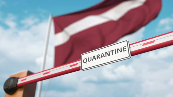 Barrier Gate with QUARANTINE Sign Opens at Flag of Latvia alt