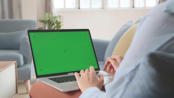Female Using Laptop With Green Screen Display