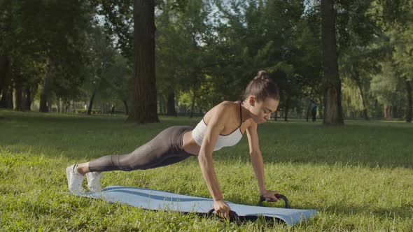 Active Woman Exercising with Fitness Push-ups Bars