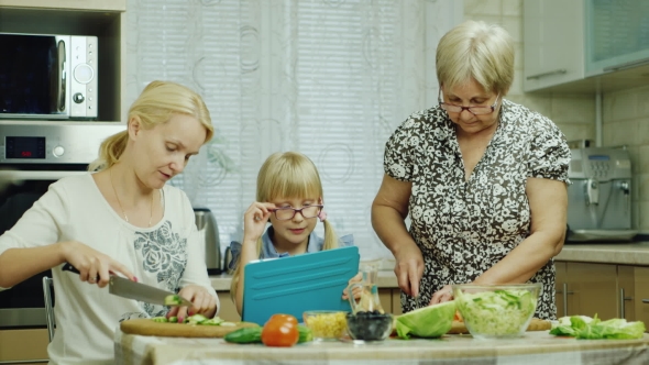 For Three Generations, the Family Together Prepare a Salad in the Kitchen. Grandma, Mom and