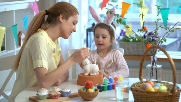 Mother and Her Little Daughter with Bunny Ears Painting Easter Bunny