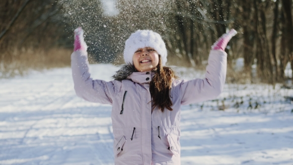 Little Girl Throwing a Handful of Snow Up In the Air