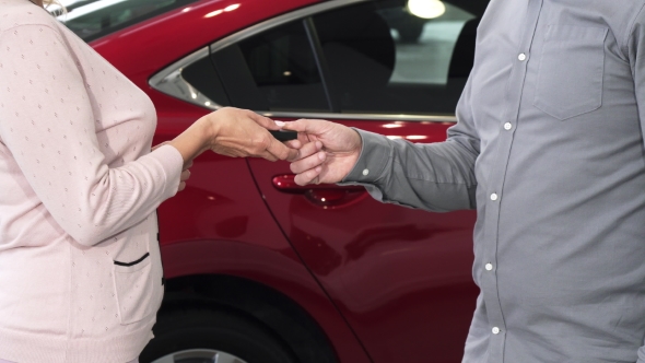 Cropped Shot of a Woman Receiving Keys To Her New Auto at the Dealership