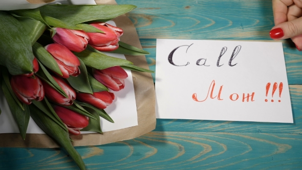 Call Mom Message Note and Tulips Flowers Bouquet on a Wooden Table. Love Relationship