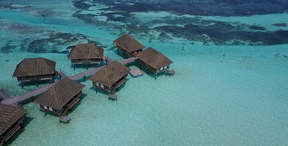 Drone flying over overwater bungalows in the Maldives