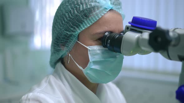 Portrait of Professional Orthodontist Examining Oral Cavity in Slow Motion with Dental Microscope