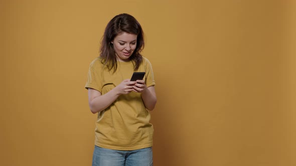 Portrait of Woman Holding Smartphone Looking at Touchscreen Texting Friend Recieving Extraordinary