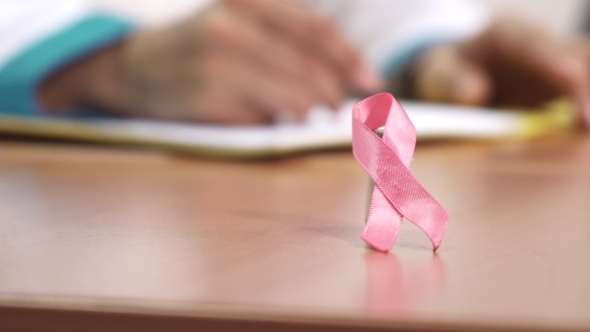 Pink Ribbon Breast Cancer Awareness Symbol on the Table of a Doctor