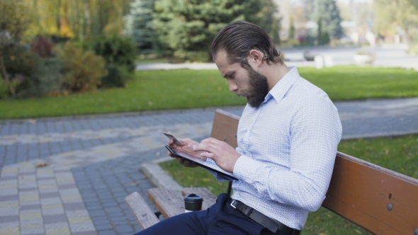 Handsome Man Using Credit Card and Tablet on the Street Bench