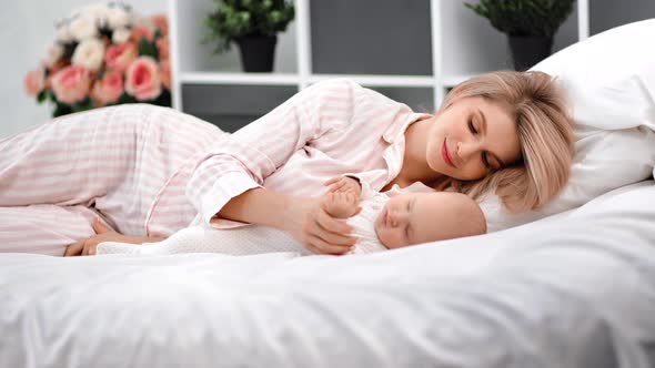 Female Stroking Son or Daughter Relaxing at Comfortable Bedroom