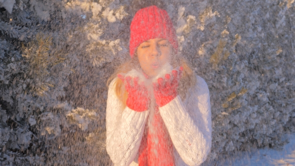 Joyful Woman Having Fun Blowing Snow And Enjoy A Magical Winter Wonderland