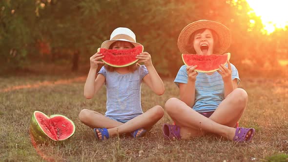 Two Preschool Smiling Child Sister Eating Watermelon at Summer Park with Sunset