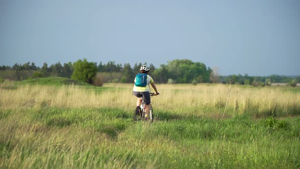 Woman Cyclist Moving On Bike On Countryside