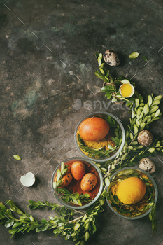 gs in spices with quail eggs, yolk and green branches over old metal background. Top view, space. Toned image
