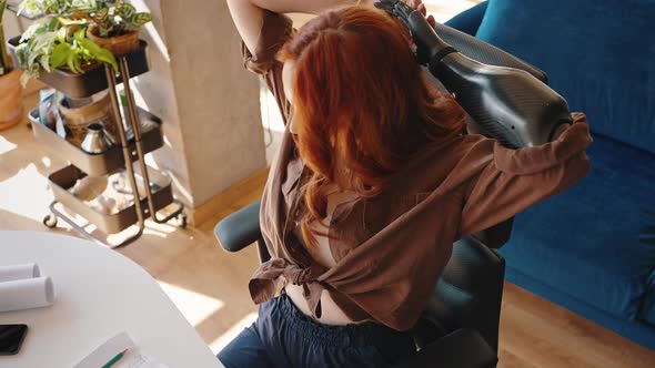 The Amputee Girl Leaned Back in Her Work Chair After the End of the Working Day