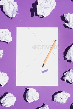 Blank white page and pen laying on violet background