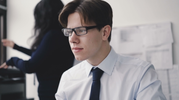 Young Businessman Typing on Keyboard at Secretary in Office