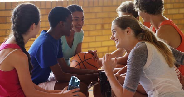 High school kids interacting while relaxing in the court