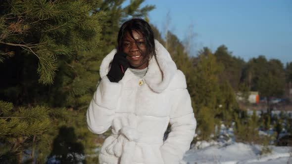 Girl with Black Skin Walks Along Forest and Talks on Phone