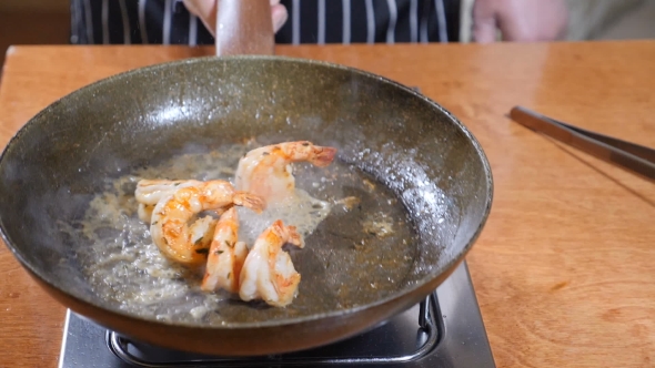 Chef Preparing Flambe Style Dish on a Pan Oil and Alcohol Ignite with Open Flames Stiring