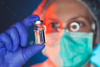 medical professional with vaccine bottle.