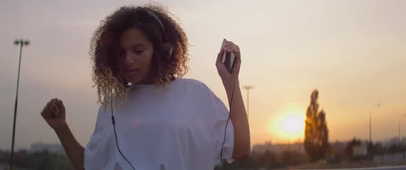 Video of African young woman in headphones dancing to the music. Shot with RED helium camera in 8K.