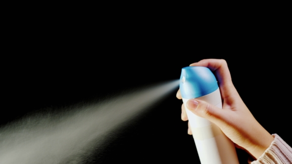 Hand with an Aerosol Can. Spray Spray on a Black Background