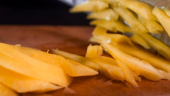 The Chef in Black Apron Cuts Vegetables