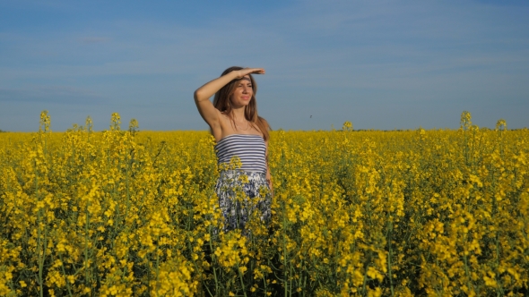 Portrait of Beautiful Brunette Young Girl in Yellow Field Looks on the Sides