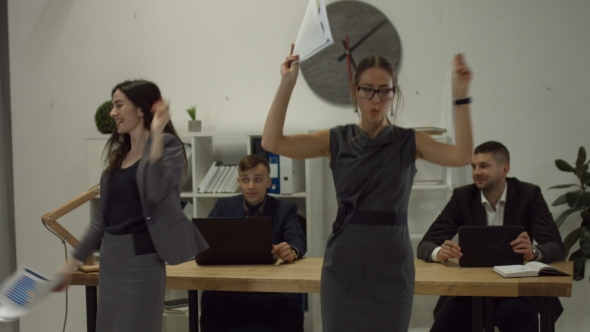 Two Excited Businesswomen Throwing Business Papers