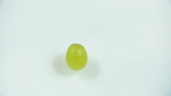 The Berry of Green Grapes Falls Into Fresh White Milk in