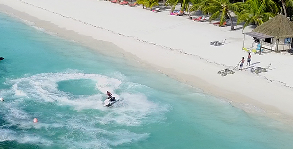 Jet Ski Spinning Close to the Shore of Stunning Tropical Island and White Sandy Beach