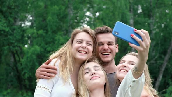 Friends have fun in the Park on a picnic making a group selfie