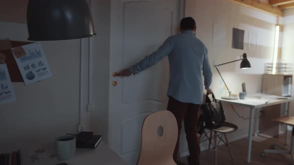 Middle Eastern Businessman Entering Office and Working on Laptop at Desk