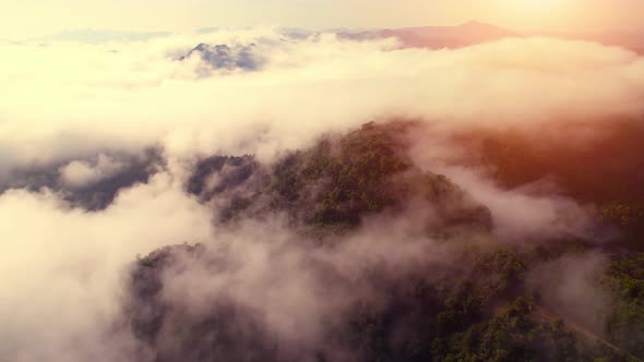 Aerial view from a drone over mountain fog during sunrise