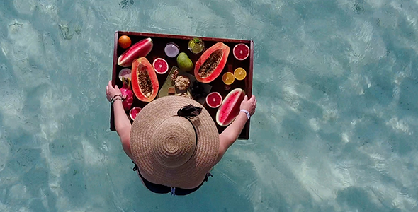 Girl Eating Huge Tropical Fruit Platter Surrounded by Crystal Clear Ocean