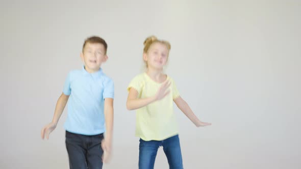 Two Cheerful Children Face and Boy Dancing in the Studio on a White Background