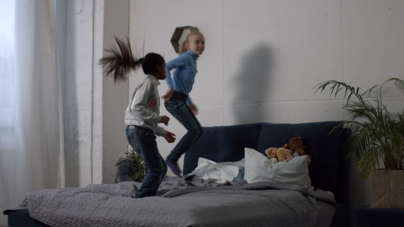 Positive Multi Ethnic Kids Jumping on the Bed