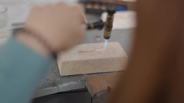 Professional Jeweler Using Blow Torch Melting A Piece Of Metal