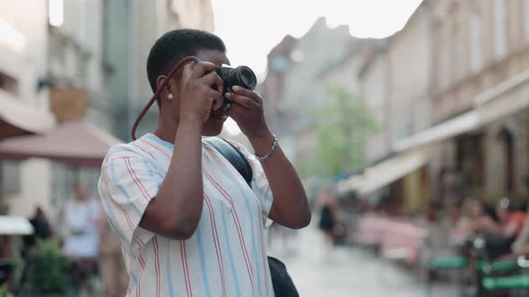 African Woman Taking Photos of Old City in Retro Camera