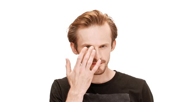 Young Handsome Man Touching Mustache and Eyebrows Smiling Over White Background